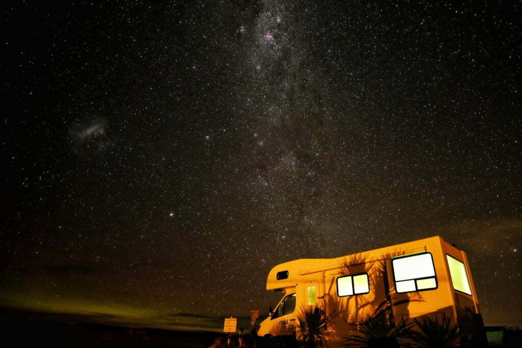 a yellow bus on a road at night