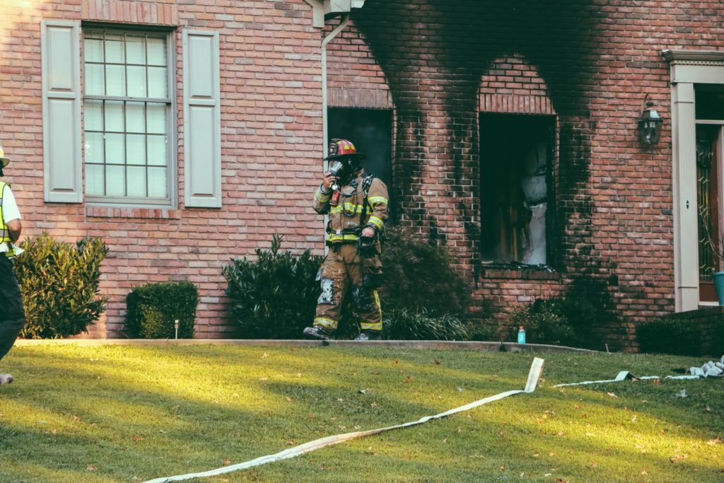 a firefighter spraying water on a house