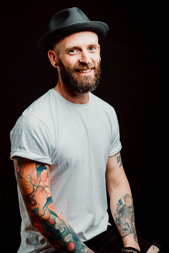 a man with tattoos and a hat