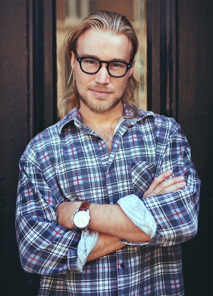 a man with glasses and a plaid shirt