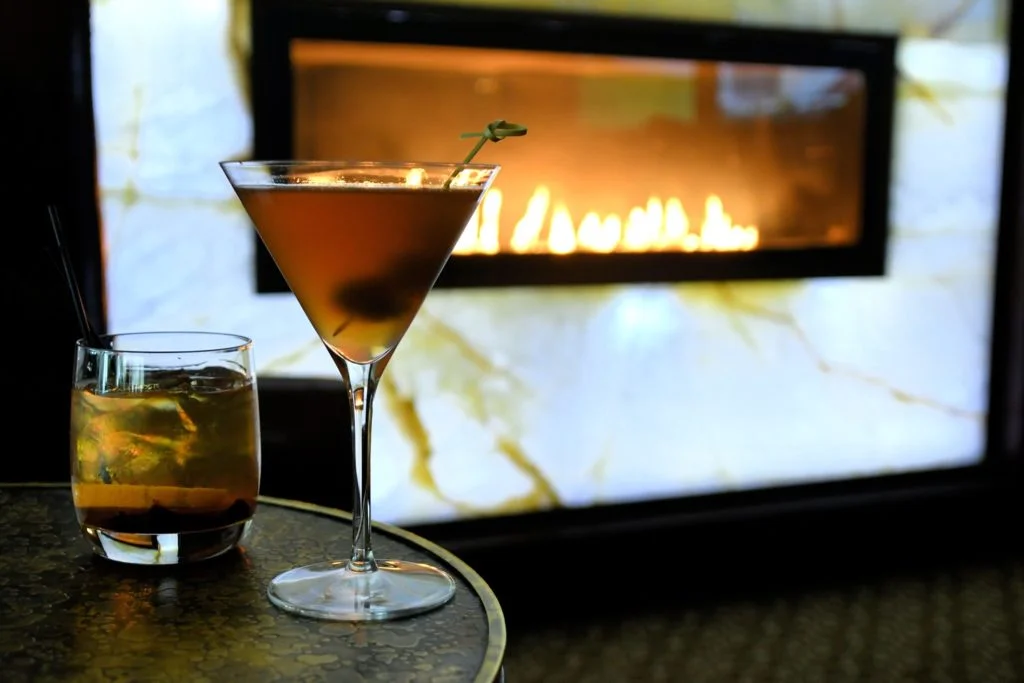 a couple of glasses of liquid next to a television