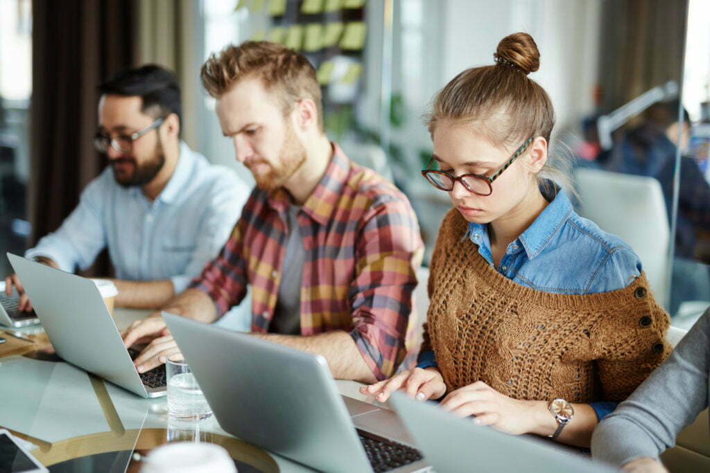 a group of men looking at a laptop