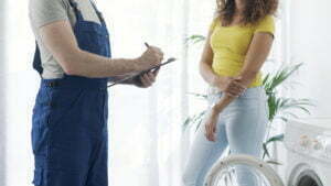 Technician performing a check-up on a washing machine