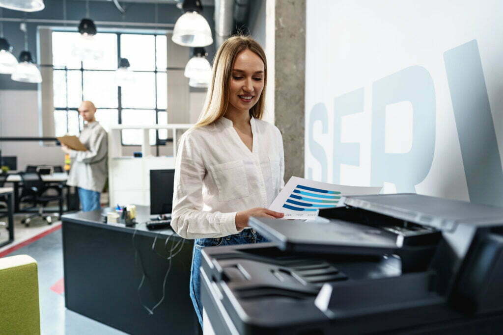 young employee using modern printer in office 2022 06 17 18 58 25 utc scaled